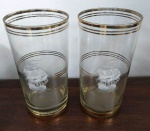 Par de copos long drink em vidro antigo com detalhes em dourado e jateamento com  imagem de um  navio. Mede: 14 cm(Am)
