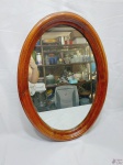 Espelho de parede oval com moldura em madeira. Medindo 67cm x 47cm.