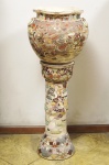 Conjunto de coluna e cachepot de porcelana japonesa Satsuma, século XIX. Fartamente decorado em relevo com figuras. Altura total 110 cm, diâmetro do cachepot 35 cm.