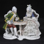 Grupo escultórico de porcelana alemã, manufatura Reichmannsdorf, fundada em 1864. Representando casal jogando xadrez. Peça no estado, medida 17 x 20 x 10 cm.