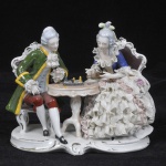Grupo escultórico de porcelana alemã, manufatura Reichmannsdorf, fundada em 1864. Representando casal jogando xadrez. Peça no estado, medida 17 x 20 x 10 cm.