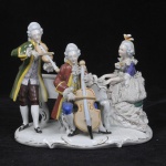 Grupo escultórico de porcelana alemã, manufatura Reichmannsdorf, fundada em 1864. Representando grupo musicista. Algumas perdas nas rendas, medida 22 x 25 x 15 cm.