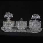 Lindo conjunto para toillete em pesado cristal francês, circa 1900. Robusta lapidação, composto de 4 peças, medida da bandeja 39 x 17 cm, medida do frasco maior 11 x 16 cm, alguns bicados.