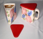 Duas leiteiras de formato triangular em cerâmica,  tampa e filtro de plástico, medida 16 x 12 x 19 cm.