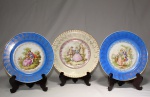 Três pratos de porcelana alemã, manufatura Hutschenrether-Selb, Bavária, decorados com cenas românticas de Fragonard, diâmetro 25 e 27 cm.