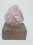 Cristal de rocha na tonalidade rosa sobre base de madeira. Alt. total18cm. Base 13 x 13cm.
