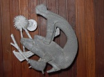Escultura em metal para pendurar representando jovem com pássaro e flor. Alt. 47cm.