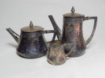 Parte de serviço para chá e café em metal espessurado a prata: bule para chá, bule para café e leiteira, bordas decoradas com frisos, pega das tampas dos bules em formas de ponta-de-lança, manufatura Royal Metal. Desgastes do tempo. Alts. 14, 11 e 5cm.