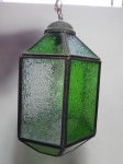 Lustre para 1 lâmpada, estrutura sextavada em metal amarelo, bojo em vidro verde ladrilhado. Funcionamento elétrico desconhecido. Escudo soltando da corrente. Alt. 60cm.