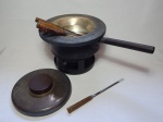 Conjunto para fondue em metal espessurado a prata, composto por rechaud, panela e talheres específicos com cabos em madeira. Apresenta desgastes do tempo. Total 24 x 28 x 45cm.
