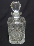 Garrafa em cristal lapidado no padrão Bohemia com caneluras, estrelados e geométricos, tampa em esfera facetada. Alt.25cm.