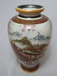 Vaso em faiança japonesa ricamente decorado com policromia representando paisagem típica de pagodes e cerejeiras, detalhes em douração. Alt. 32cm.