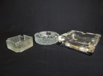 Três cinzeiros em vidro translúcido moldado, sendo 2 no padrão ponta-de-diamante e1 moldado liso. Maior 5 x 14 x 14cm.