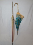 Duas antigas sombrinhas, sendo uma com cabo em metal e uma com cabo em madeira no feitio de bambu. Comps. 78cm.