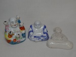 Três esculturas em porcelana chinesa, 2 representando Buda e 1 representando sacerdote para parede. Alts. 14, 11 e 8cm.