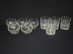 Nove copos para whisky em vidro, 5 lapidados no padrão dedão e 4 com blocos. Alts. 9 e 10cm.