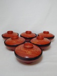 Seis bowls com tampa em laca japonesa, fundo externo em carmesim, decoração em douração. Diâms. 13cm.
