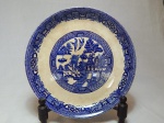 WOODS & SONS - Prato para bolo em faiança inglesa, decoração azul e branca no padrão willow. Cerca 1917. Craquelet, fio de cabelo e bicado. Diâm. 28cm.