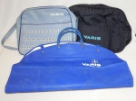 MEMORABILIA - Três peças da VARIG: a) Bolsa a tiracolo em napa azul clara com logotipo da companhia. 20 x 35cm. b) Capa para transporte de paletó em plástico azul e logomarca da companhia. c) Bolsa de mão em nylon azul marinho com logomarca da companhia. 28 x 38cm. No estado.
