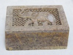 Caixinha indiana em pedra sabão, tampa com dobradiça, vasada e gravada com figura de elefante. 4 x 10,5 x 8cm.
