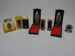 Quatro brindes da Petrobras e 1 isqueiro de mesa: a) Dois isqueiros dourado e preto, no estojo, mini relógio com caixa em aço escovado. Alt. 4,5cm e mini lanterna Artpen. b) Isqueiro em suporte de acrílico aplicado com brasão do Comando do Controle Naval do Tráfego Marítimo - marinha do Brasil. Alt. 7,5cm.