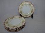 NORITAKE - Seis pratos rasos em porcelana japonesa, borda com esmaltagem bege, medalhões de buquê de flores circundado por volutas e acantos interligados por guirlandas, friso grená. Marcado no fundo. Diam. 26,5cm.