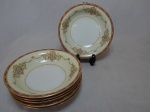 NORITAKE - Seis pratos fundos em porcelana japonesa, borda com esmaltagem bege, medalhões de buquê de flores circundado por volutas e acantos interligados por guirlandas, friso grená. Marcado no fundo. Diam. 19cm.