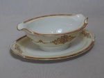 NORITAKE - Molheira em porcelana japonesa, borda com esmaltagem bege, medalhões de buquê de flores circundado por volutas e acantos interligados por guirlandas, friso grená. Marcado no fundo. 7,5 x 23 x 15cm.