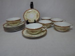 NORITAKE - Seis xícaras para chá com respectivos pires, porcelana japonesa, borda com esmaltagem bege, medalhões de buquê de flores circundado por volutas e acantos interligados por guirlandas, friso grená. Marcado no fundo. 1 xícara com bicado.