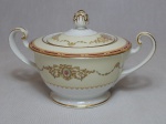 NORITAKE - Açucareiro em porcelana japonesa, borda com esmaltagem bege, medalhões de buquê de flores circundado por volutas e acantos interligados por guirlandas, friso grená. Marcado no fundo. Pega em pinha. Alt. 11cm.