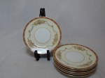 NORITAKE - Seis pratos para lanche em porcelana japonesa, borda com esmaltagem bege, medalhões de buquê de flores circundado por volutas e acantos interligados por guirlandas, friso grená. Marcado no fundo. Diam. 16cm.