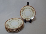 NORITAKE - Seis pratos para lanche em porcelana japonesa, borda com esmaltagem bege, medalhões de buquê de flores circundado por volutas e acantos interligados por guirlandas, friso grená. Marcado no fundo. Diam. 16cm.