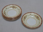 NORITAKE - Cinco bowls em porcelana japonesa, borda com esmaltagem bege, medalhões de buquê de flores circundado por volutas e acantos interligados por guirlandas, friso grená. Marcado no fundo. Diam. 14cm.