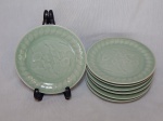 Sete pratos para sobremesa em porcelana chinesa celadon, vitrificada em verde oliva, centro decorado com figuras de peixes em sutil relevo. Diâm. 17cm.