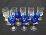 Doze taças para aperitivos, sendo 6 em demi-cristal translúcido lapidado com caneluras, e 6 em vidro azul. Alts. 8,5cm e 7,5cm.