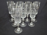 Oito flutes em demi-cristal translúcido, pés em bolacha, lapidação dedão, haste facetada. Alt. 20cm.