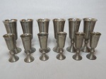 Doze taças para aperitivos em estanho polido. Alts. 13 e 10cm.