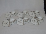 Seis xícaras com pires em fina porcelana japonesa dita casca de ovo, fundo da xícara com litofania representando gueixa, pires em porcelana vitrificada ditos "almoçadeira", decoração em frisos prateados representando árvores de bambus. Marcados Nunome, Japão. Tamanho dos pires 22 x 18cm.
