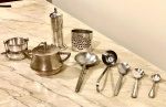 Nove peças diversas em metal: 4 colheres, 1 concha, 1 porta-guardanapos 1 potinho, 1 coador para chá e 1 paliteiro. Alt. maior 13cm, comp. menor 8cm.
