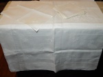 Toalha de mesa e 12 guardanapos, cambraia de linho branco bordada com flores e vazados. Com manchas. 220 x 175cm e 40 x 40cm.
