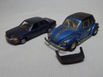 Duas réplicas miniatura de automóveis: a) Mercedes-Benz 280S, modelo nº 200, escala 1:35, manufatura alemã NGZ Models. Comp. 15cm. b) Modelo antigo Volkswagen, escala 1:25, numeração 515, comp. 17cm. No estado.