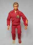 Réplica "action figure" do personagem Steve Austin, da série Six Million DollarMan, articulável, em plástico, olho esquerdo com lente onde pode-se ver através da mesma. Falta um dos tênis. Alt. 33cm.