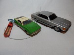 Dois antigos carros de controle remoto: a) Mustang Mach 1 em metal esmaltado, controle remoto com fio. Não testado e sem garantias. Comp. 26cm. b) Mercedes-Benz 450 SLC em plástico rígido. Falta controle. Comp. 35cm.