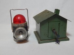 Duas antigas peças: a) Lanterna dupla em metal, com luzes branca e vermelha, alça flexível. Falta o visor de uma das luzes, não testada e sem garantias. b) Cofre na forma de casa em ferro pintado de verde. Apresenta oxidação. 13 x 14 x 14cm.
