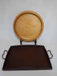 Duas bandejas em madeira; 1 redonda e 1 retangular com alças em metal. Diam. 37cm e 42 x 29cm.