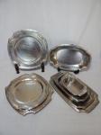 Baixela com 8 peças em inox, borda no padrão fitas cruzadas: 5 travessas retangulares e 3 quadradas. Maior 33 x 20cm.