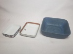Três petisqueiras distintas uma em cerâmica pintada de azul com flores, uma em porcelana branca Schmidt, uma Polovi com monograma "RR". Maior 6 x 15 x 15cm.