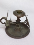 Castiçal em metal amarelo com porta-fósforos e porta-relógio. Apresenta desgastes. Alt. 11cm.