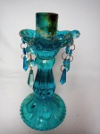 Castiçal em vidro azul moldado com decoração de caneluras, botões e pingentes, porta-velas na forma de flor. Alt. 22cm.
