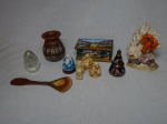 Miscelânea decorativa composta por 10 peças, entre figuras de Buda, vaso marajoara, caixinha, entre outros. Alt. maior 14cm, menor 6cm.
